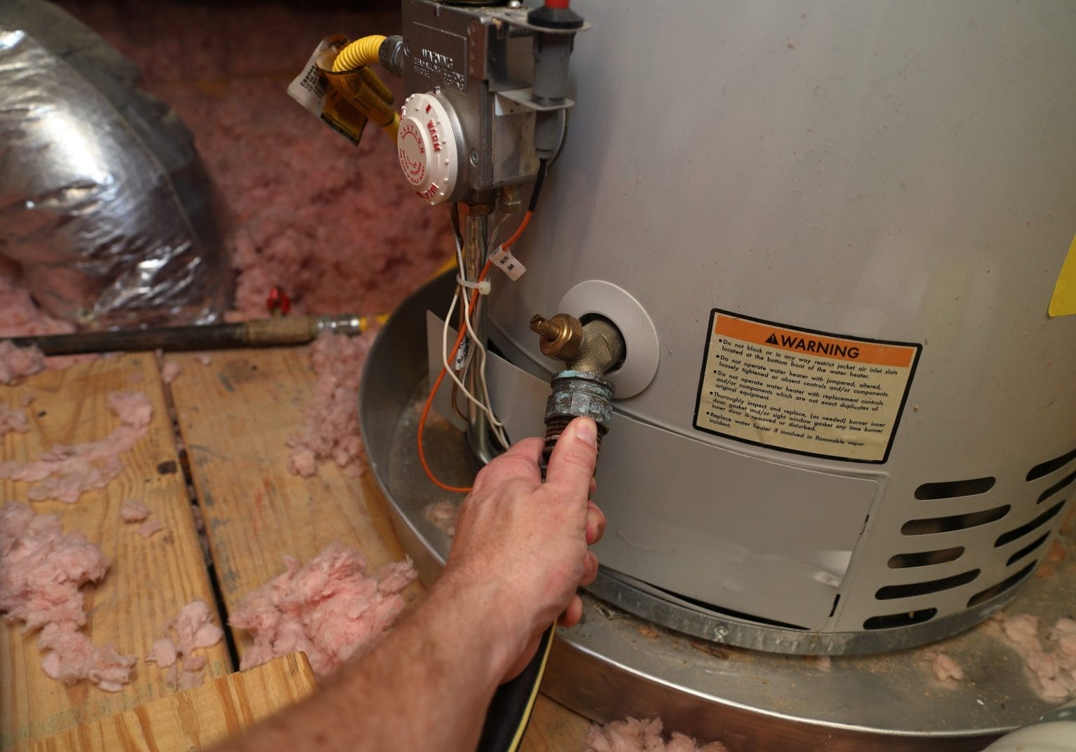 Person Draining Water Heater in Attic
